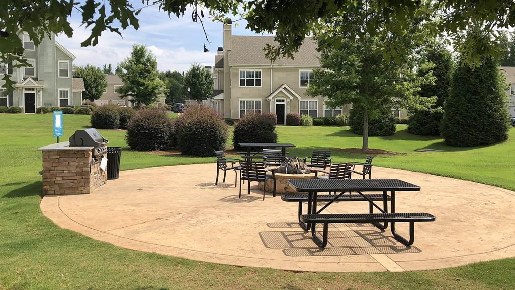 a patio with tables and chairs at Millennium Apartments Greenville SC