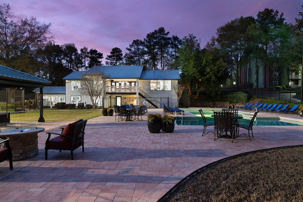a backyard with a paver patio and a swimming pool