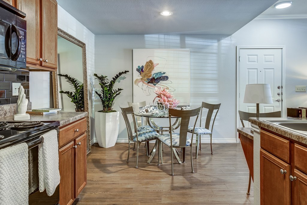 A kitchen with a dining table and chairs.