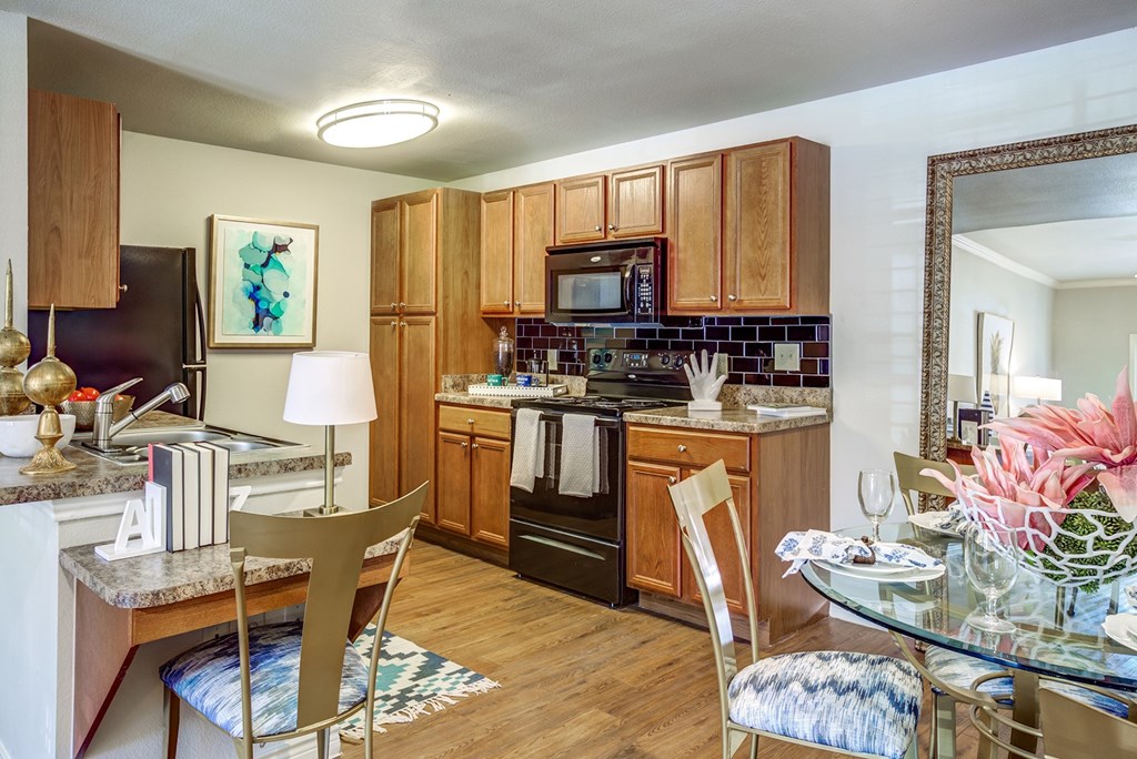 A kitchen with wooden cabinets and a black refrigerator.