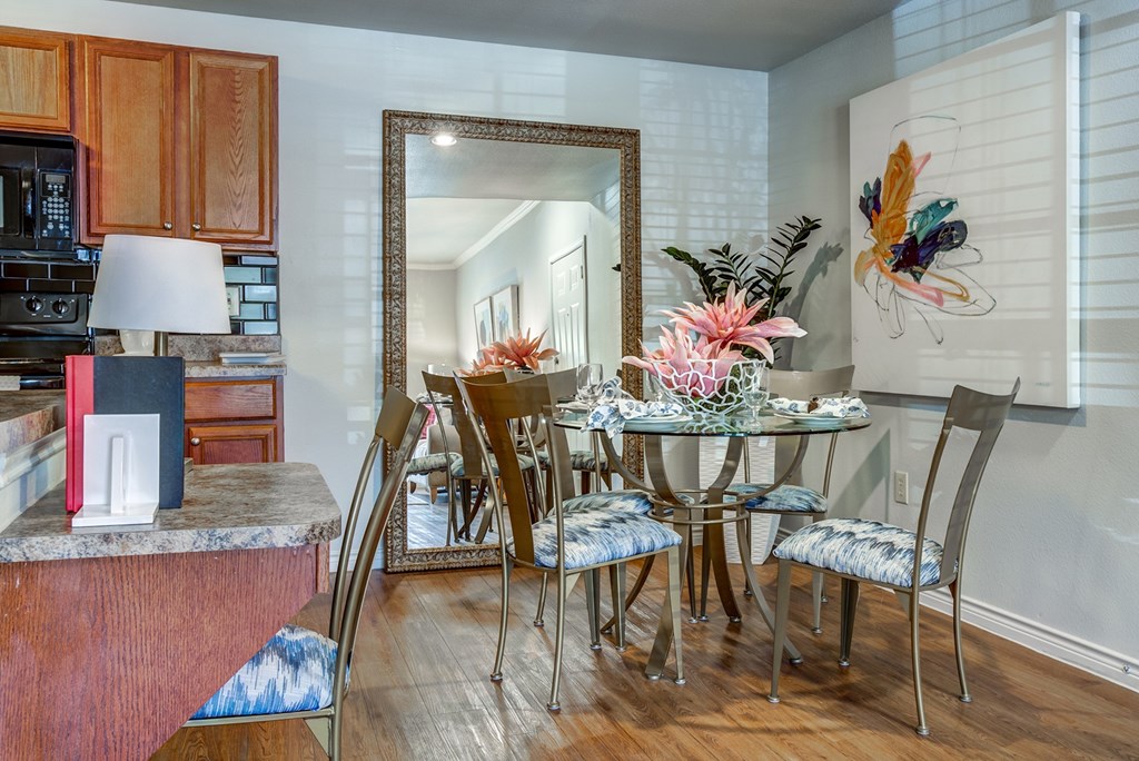 A kitchen with a dining table and chairs.