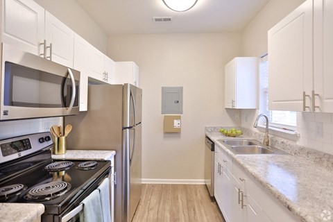 A kitchen with white cabinets and a black stove top.