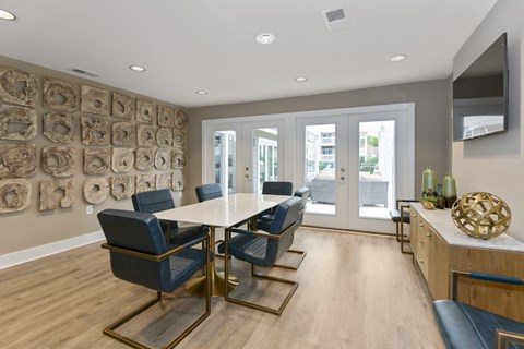 a modern room with a table and chairs and a television on the wall at Canopy apartments in South Charlotte
