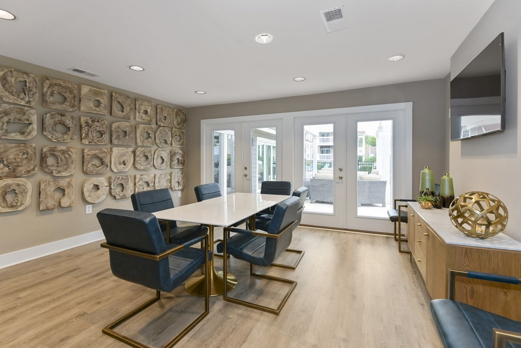 a modern room with a table and chairs and a television on the wall at Canopy apartments in South Charlotte