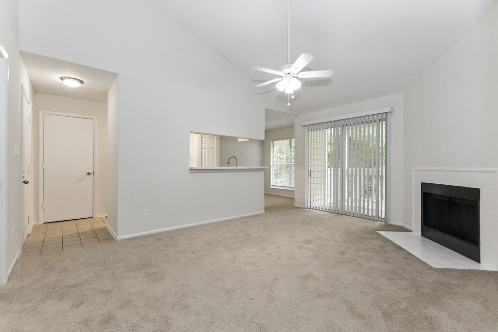 a living room with a fireplace and a ceiling fan at Canopy at Baybrook apartments in Charlotte NC