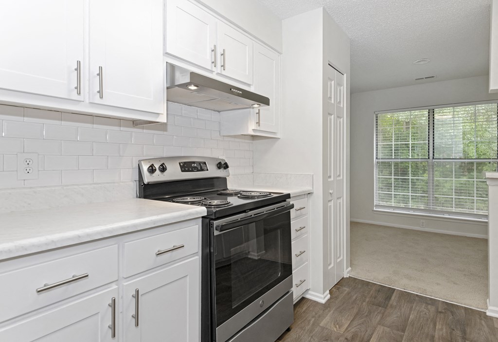 a kitchen with white cabinets and a stainless steel black stove top oven at Canopy at Baybrook apartments in Charlotte NC
