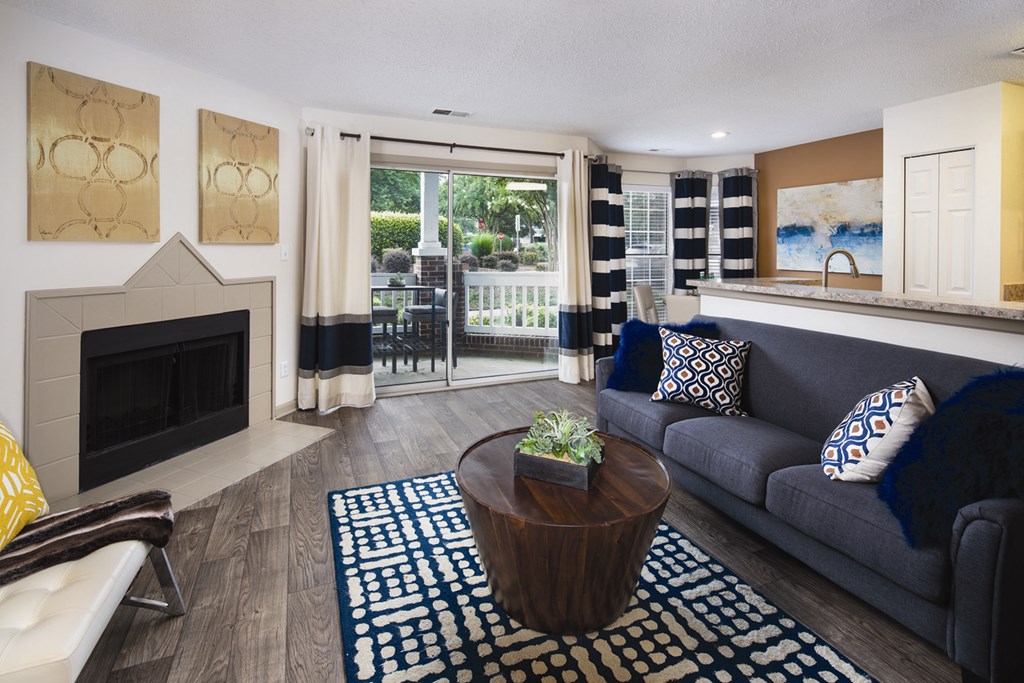 A living room with a fireplace and a blue couch.