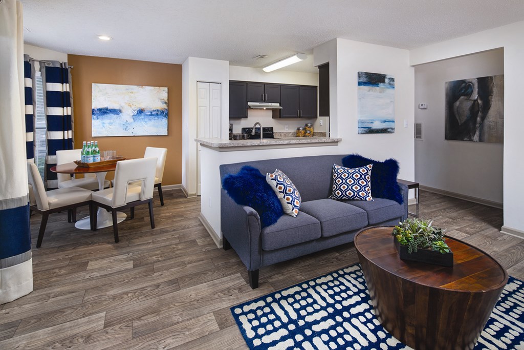 A living room with a blue couch and a wooden coffee table.