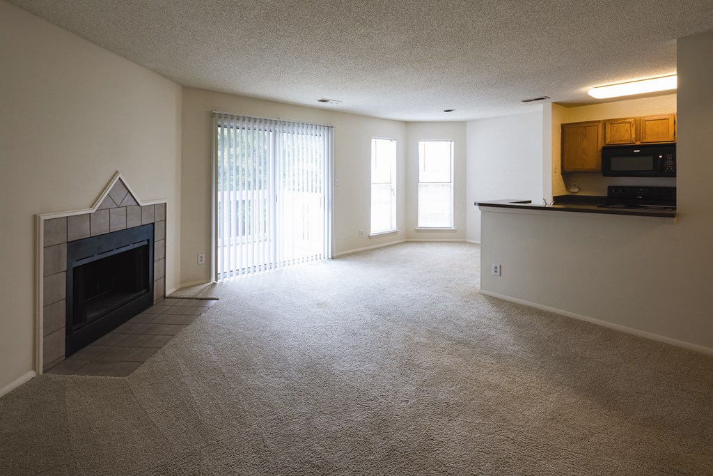 A living room with a fireplace and patio door leading out to a private patio