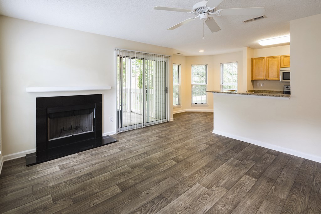 A living room with a fireplace and patio sliding glass doors.