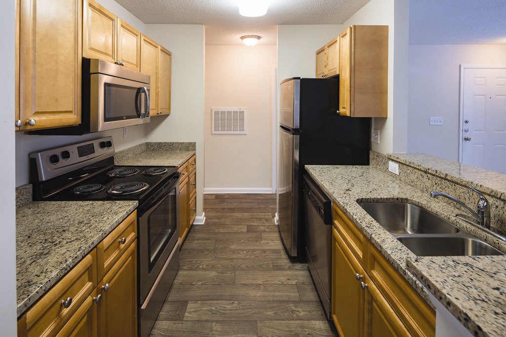 A kitchen with wooden cabinets and granite countertops.