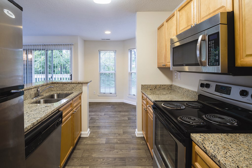 A kitchen with granite countertops and stainless steel appliances.