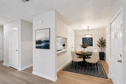 A dining room with a table set for four.