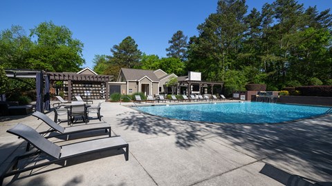 Wynnwood Vinings resident pool with lounge chairs and view of outdoor TV lounge with couches