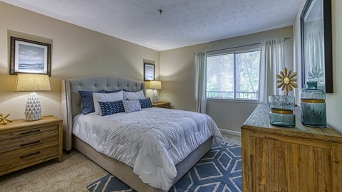 One Bedroom Apartments in Vinings, GA - Wynnwood Vinings - Furnished Bedroom with Plush Carpet Flooring and a Window