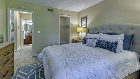 a bedroom with a large bed and a bathroom in the background at Wynnwood Vinings
