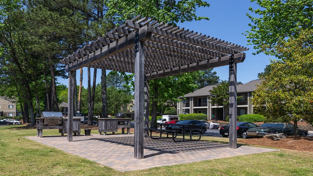 Wynnwood Vinings resident pergola in a park with a picnic table and grill