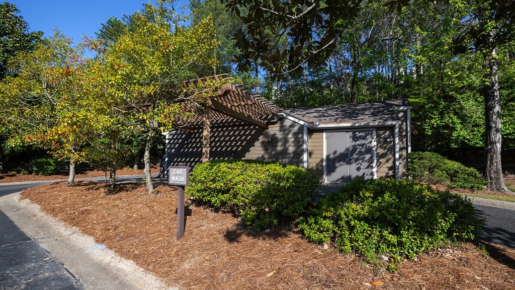 a small white building with a slanted roof and a sign in front of it at Wynnwood Vinings Atlanta