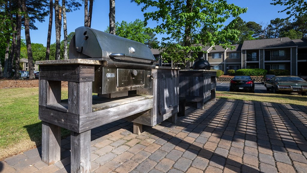 Wynnwood Vinings resident bbq grill sits on a brick patio in front of a row of apartment buildings