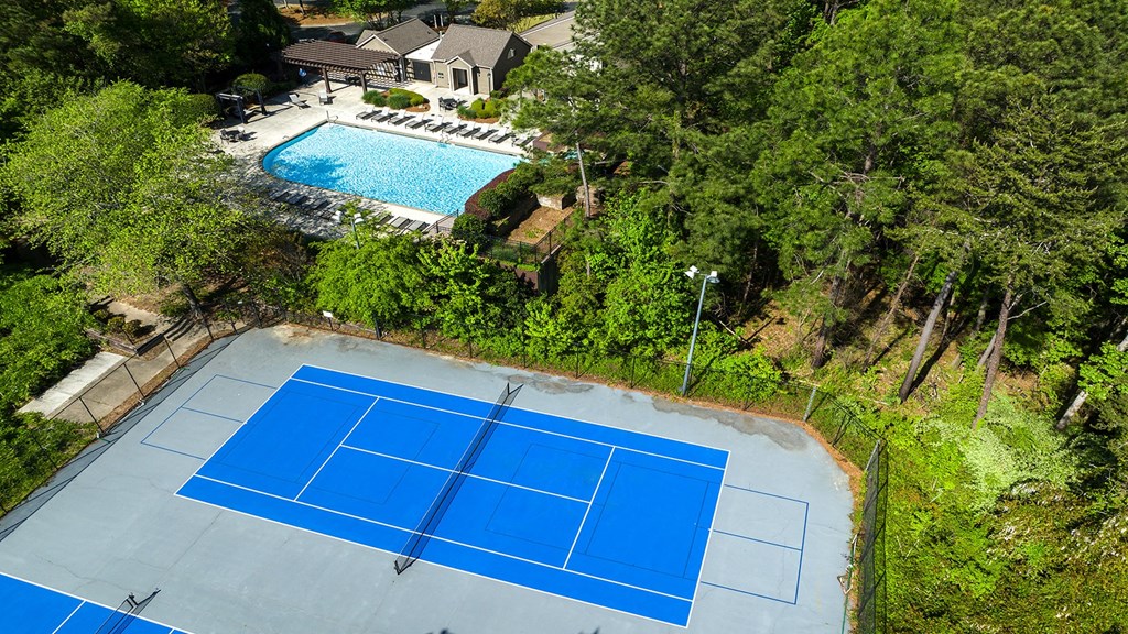 Vinings, GA Pet-Friendly Apartments - Wynnwood Vinings - Pool Area with Lounge Chairs and Two Tennis Courts, Surrounded by Beautiful Landscaping