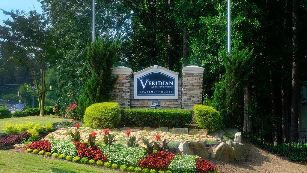 a garden with flowers and rocks in front of a yarddan sign