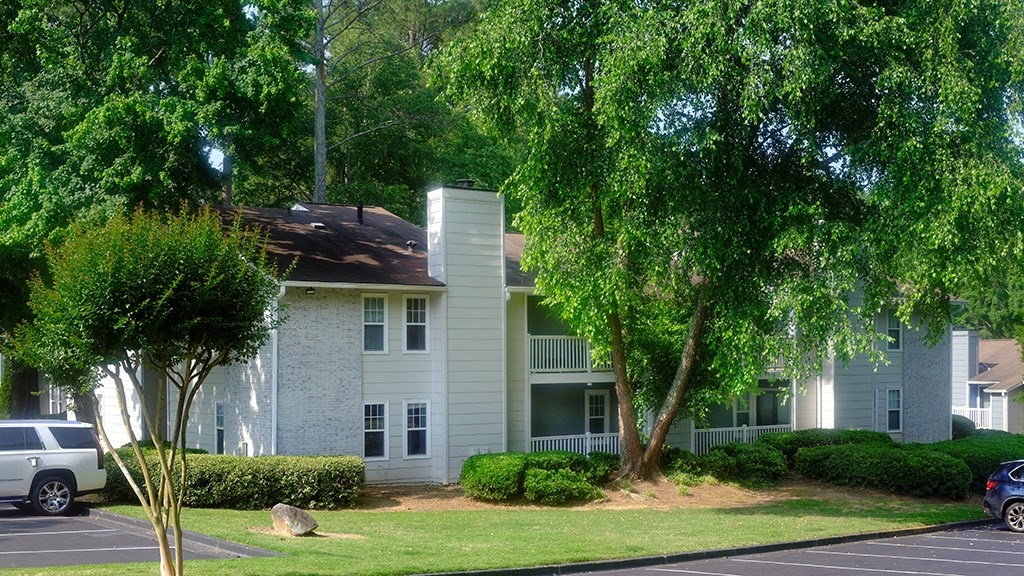 a picture of an apartment building with a large tree in front of it