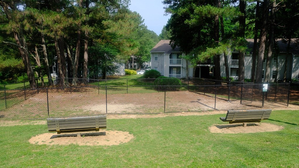 a park with two benches and a fence
