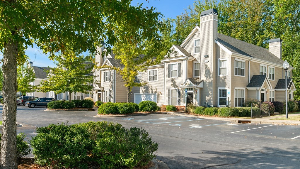 a parking lot in front of a row of apartment buildings