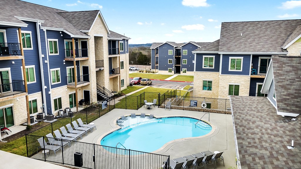 an aerial view of an apartment complex with a swimming pool