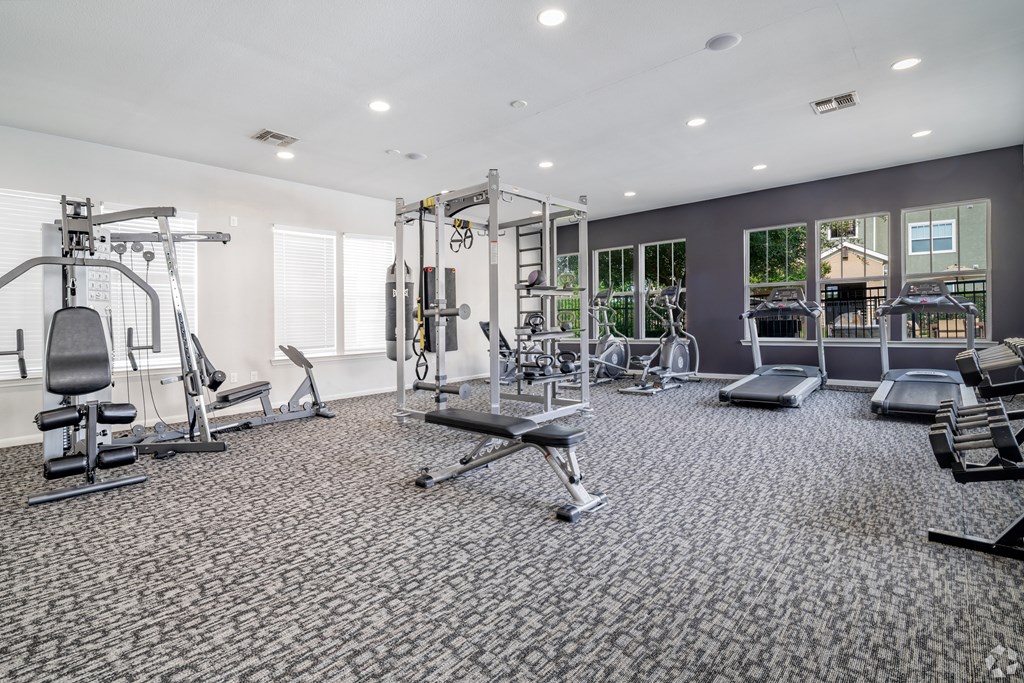 A spacious gym with a variety of equipment including treadmills, weights, and exercise machines.