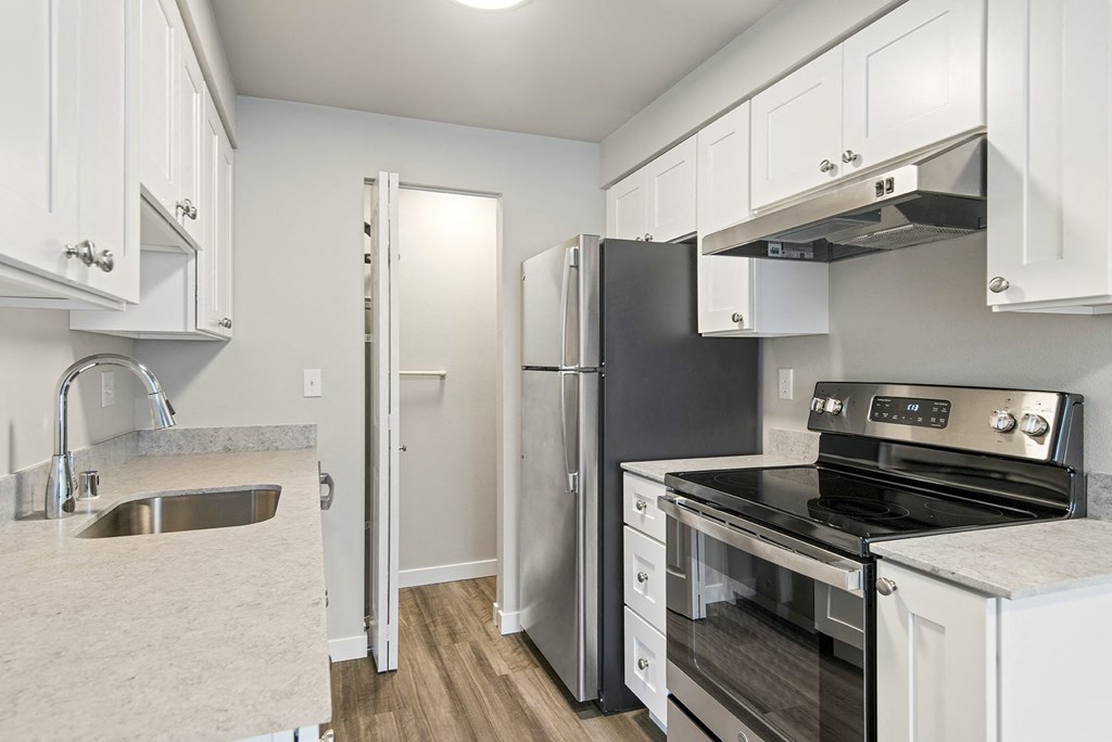a kitchen with stainless steel appliances and white cabinets