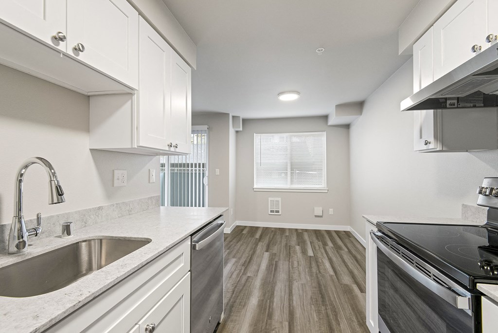 a kitchen with a sink and a stove and a window