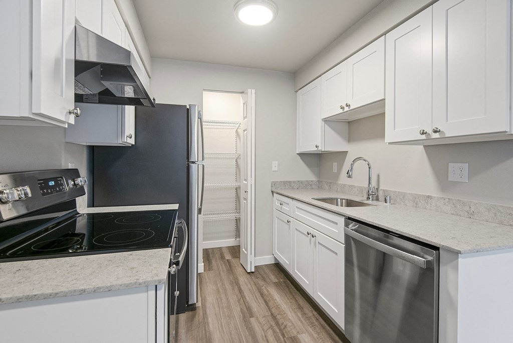 1-Bedroom Apartments in Tukwila, WA - Foster Creek - Kitchen with Marble-Style Countertops, White Cabinets, Large Pantry, and Stainless Steel Appliances