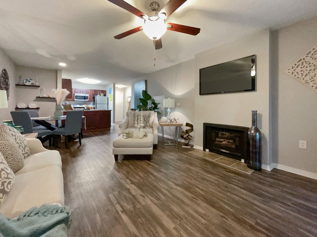 a living room with a fireplace and a ceiling fan