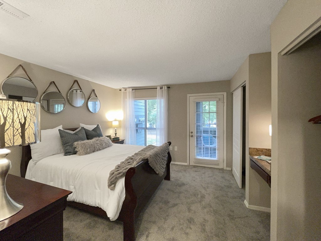 a bedroom with a large bed and a door into a bathroom