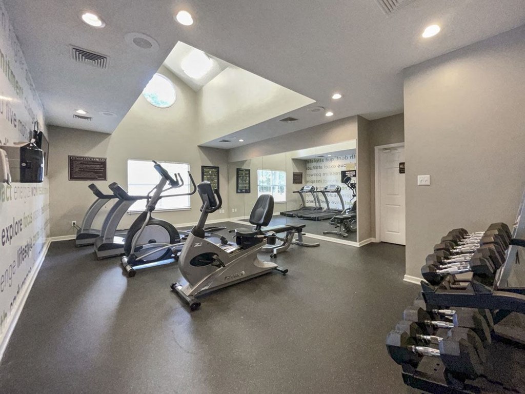 a gym with several exercise machines and a wall of shoes