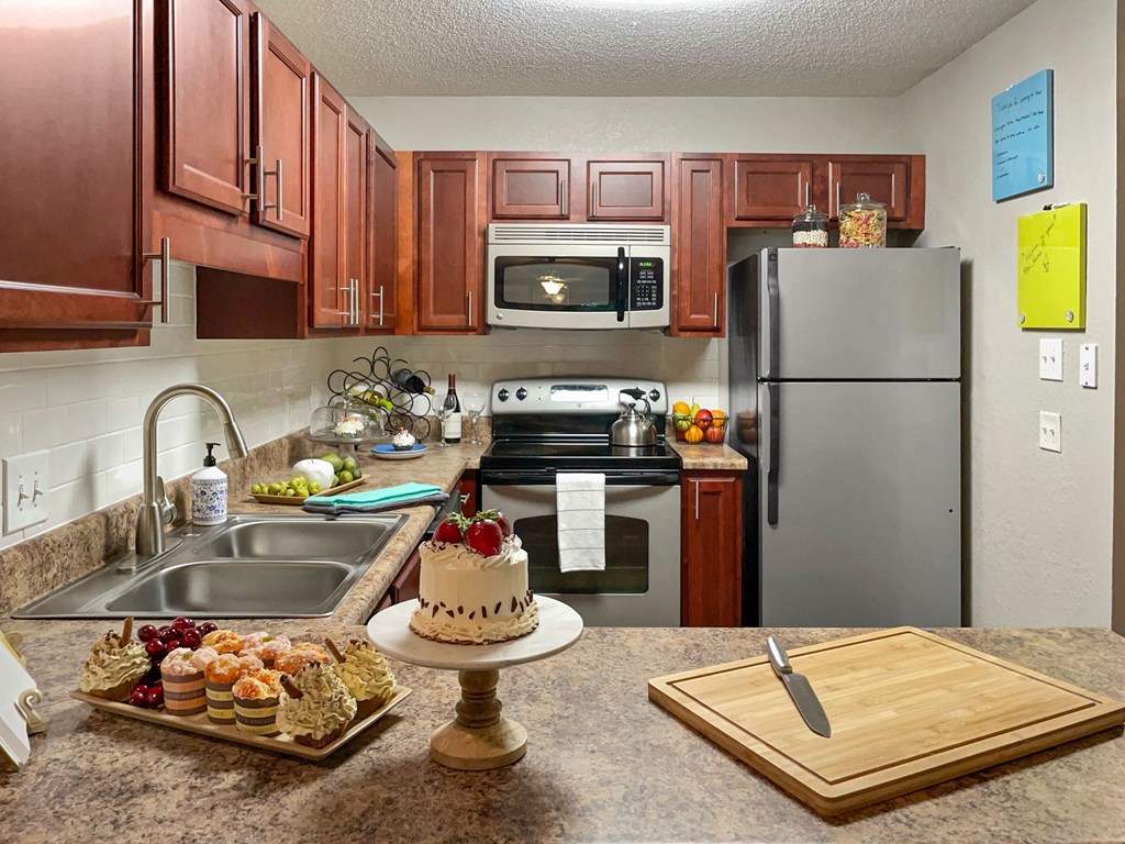 our apartments have a full kitchen with stainless steel appliances and a cake on the counter