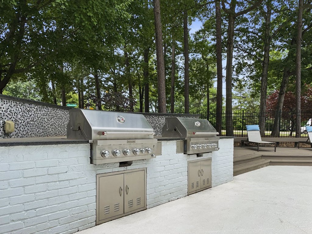 the outdoor kitchen has two grills and two refrigerators