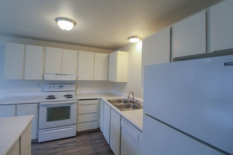 a kitchen with white appliances and white cabinets