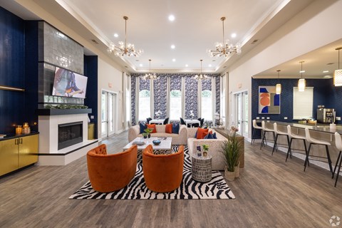 A modern living room with a zebra print rug and orange chairs.