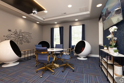A modern office space with blue chairs and a white table.