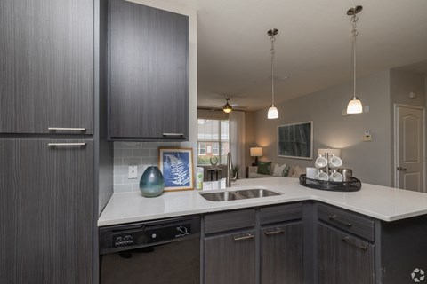 A kitchen with dark wood cabinets and a white countertop.