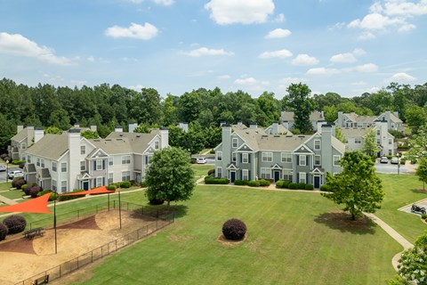 A large, grey building with a green lawn in front.