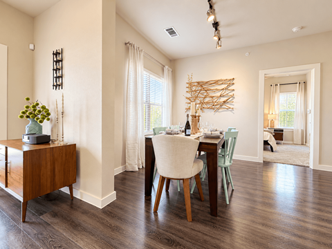 A dining room with a wooden table and chairs.