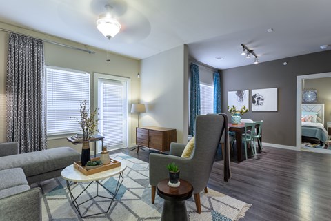 A living room with a grey couch, a white coffee table, and a grey armchair.