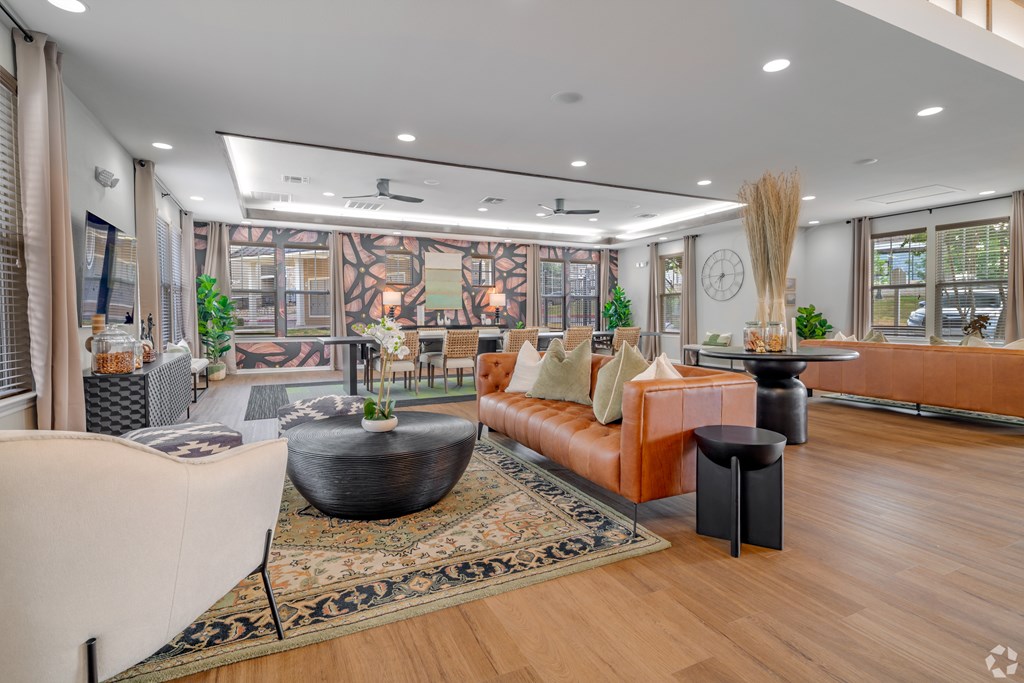 A modern living room with a large sofa, a coffee table, and a large window.