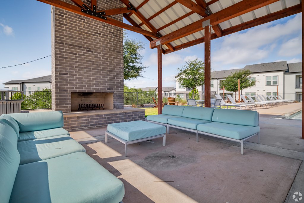 A patio with a fireplace and a blue couch.