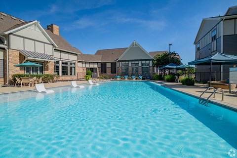 A large swimming pool in front of a house.