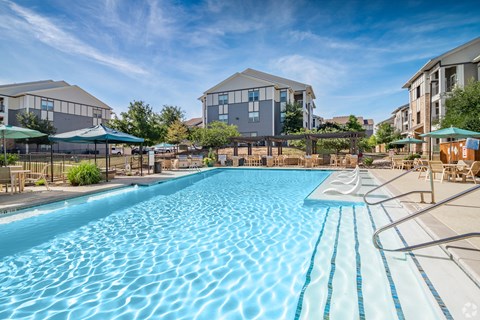 A large swimming pool in front of apartment buildings.