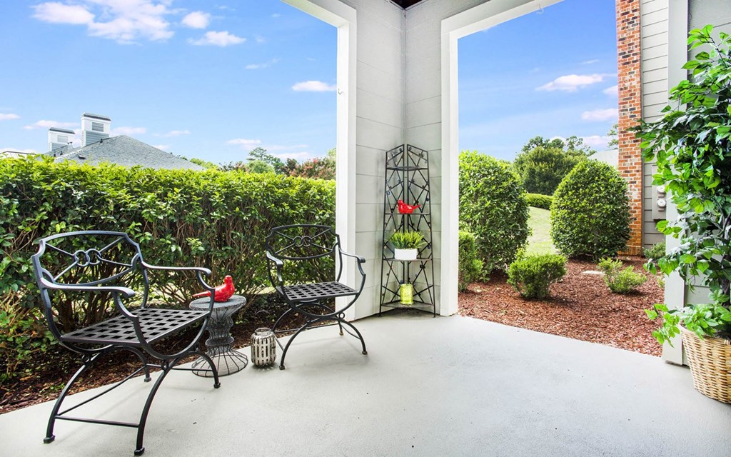 A patio with a table and chairs is surrounded by a brick wall.
